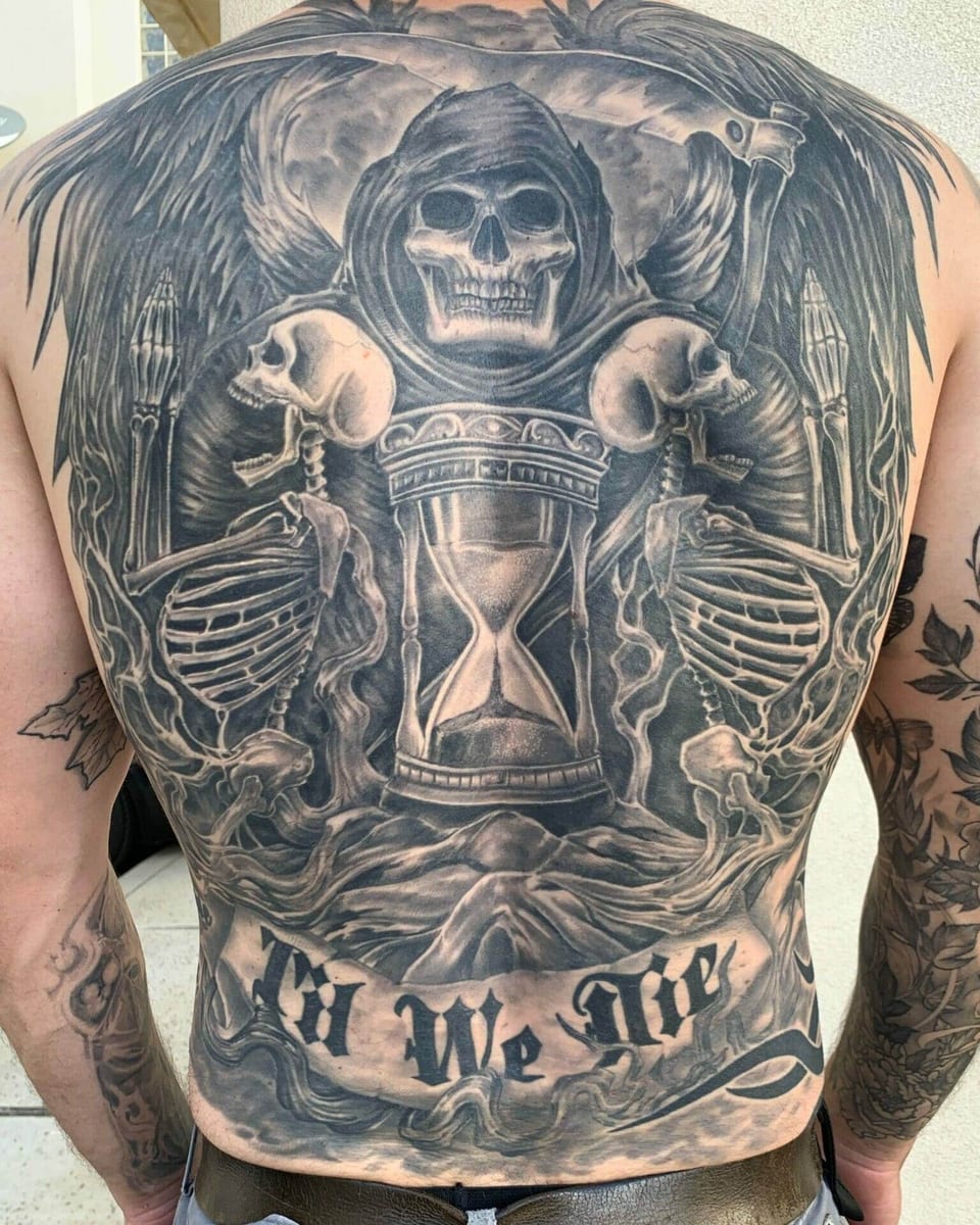 A black and grey winged grim reaper, scythe and hourglass cover the back.