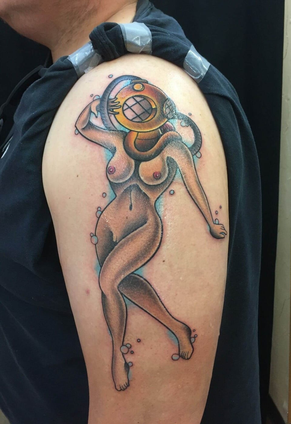 A traditional nude pin-up diver in a brass helmet appears with blue bubbles on the upper arm.