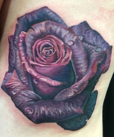 A realistic purple rose with layered petals and water droplets covers the upper arm.