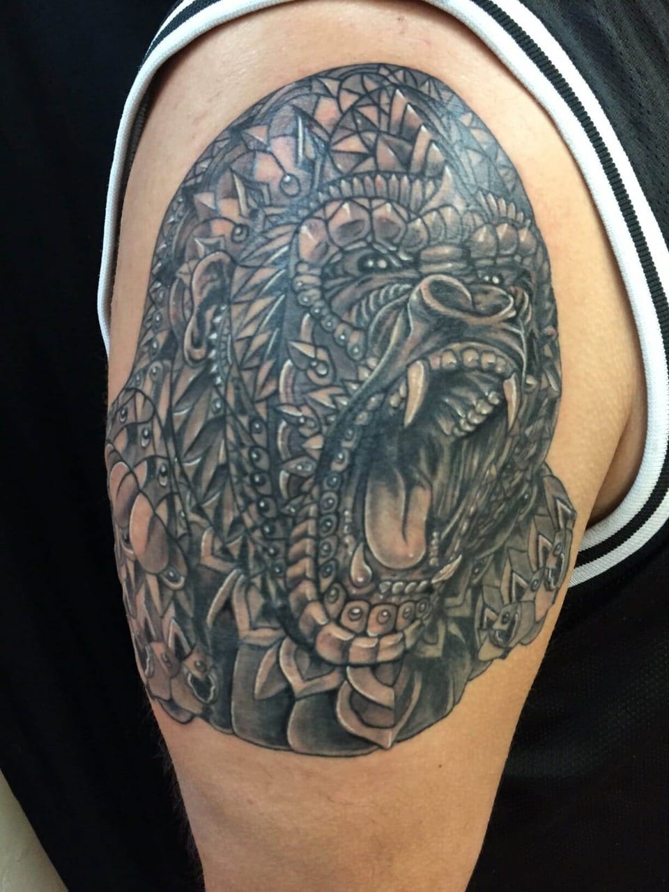 Black and grey gorilla face on an upper arm, tattooed by Seth Reynolds