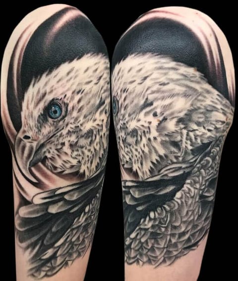 A tattoo of an eagle with blue eyes.