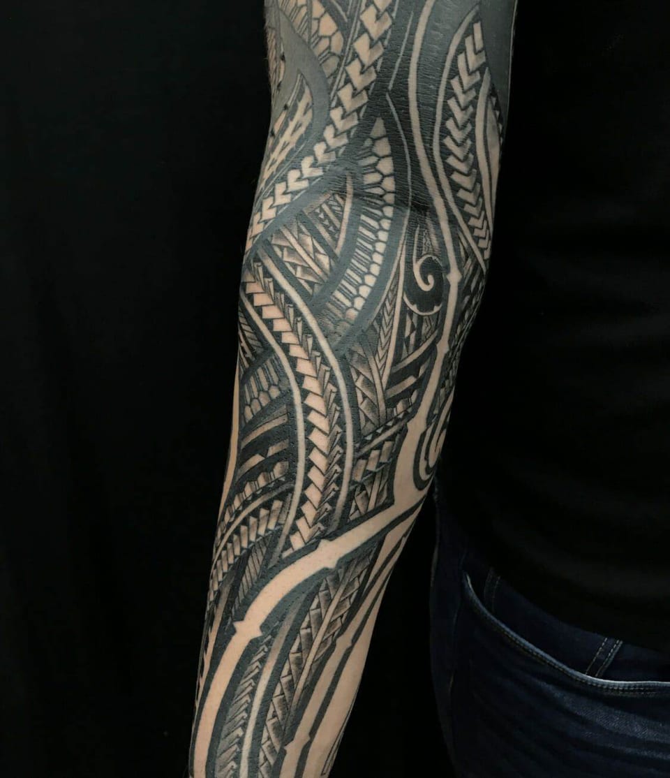 Polynesian forearm and upper arm sleeve in black, tattooed by Seth Reynolds
