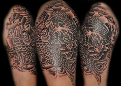 Black and grey Japanese koi swim through waves on an upper arm, shown from different angles.