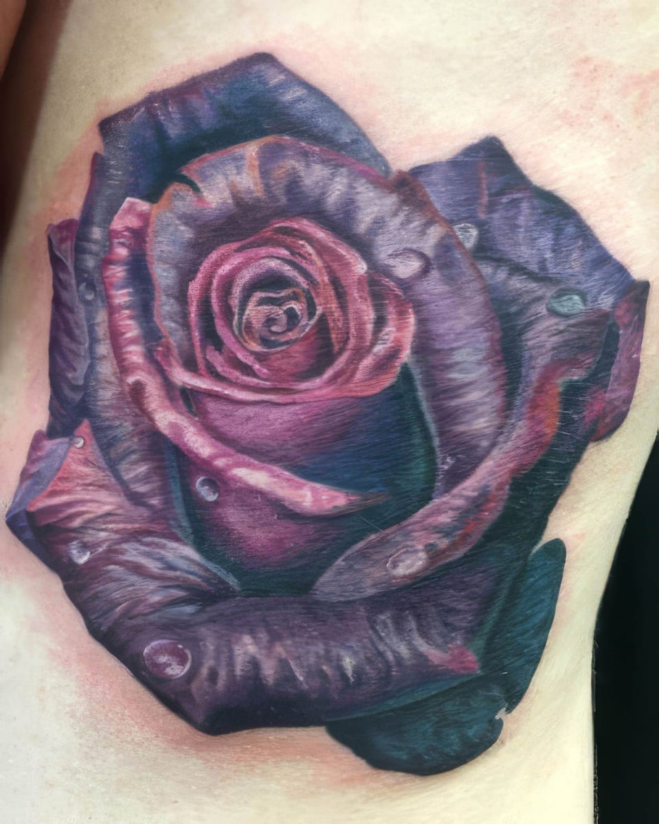 A realistic purple rose with water droplets covers an upper chest.